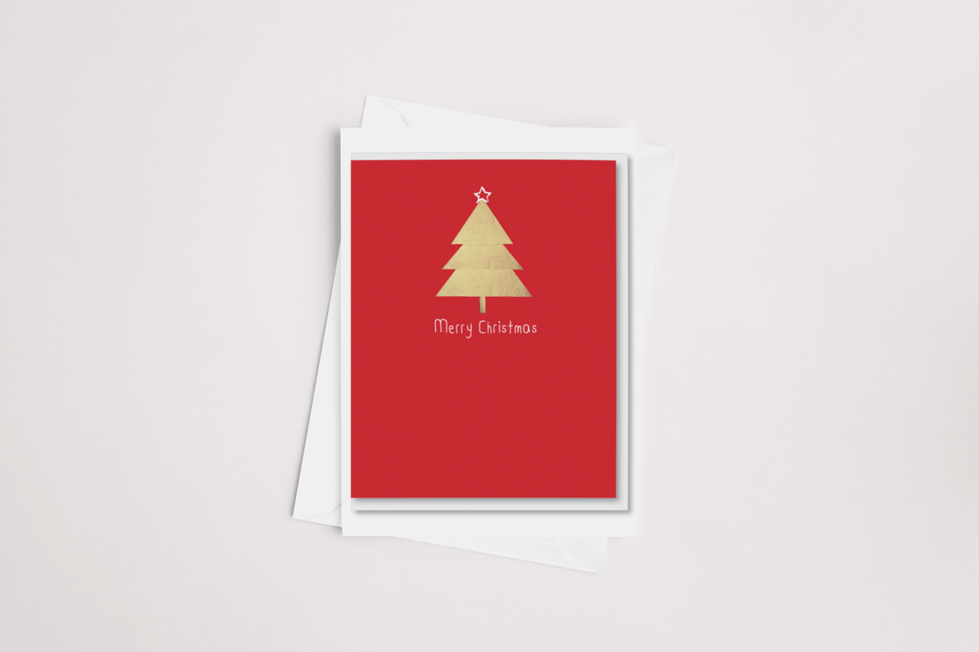 The iCandy Red & Gold Christmas Card showcases a minimalist golden tree adorned with a star on top, set against a vibrant red background. The words "Merry Christmas" are elegantly printed in white below the tree. This card comes blank inside for your personalized message, paired with a white envelope placed on a light gray backdrop.