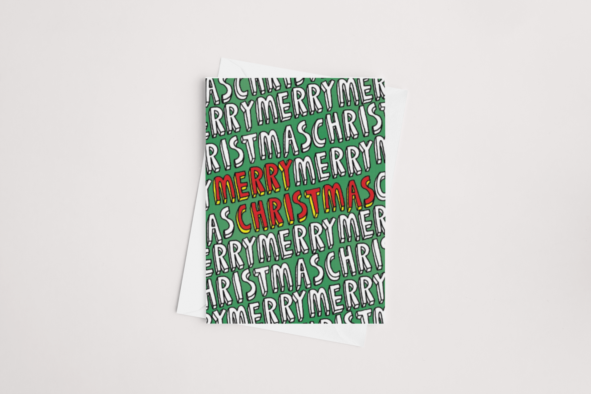 The "Merry Christmas Card" by Tuesday Print showcases a green background embellished with the phrase "Merry Christmas" in alternating white and black. At its center, "Merry Christmas" is prominently displayed in bold red and white letters. This card is blank inside, allowing you to add your personal message, and it comes with a white envelope, set against a simple white surface.